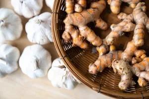 سبدی حاوی ریشه های زردچوبه که با بوته های سیر احاطه شده - خواص سیر خام